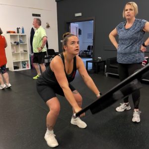 Hitsona member exercising whilst another member looks on